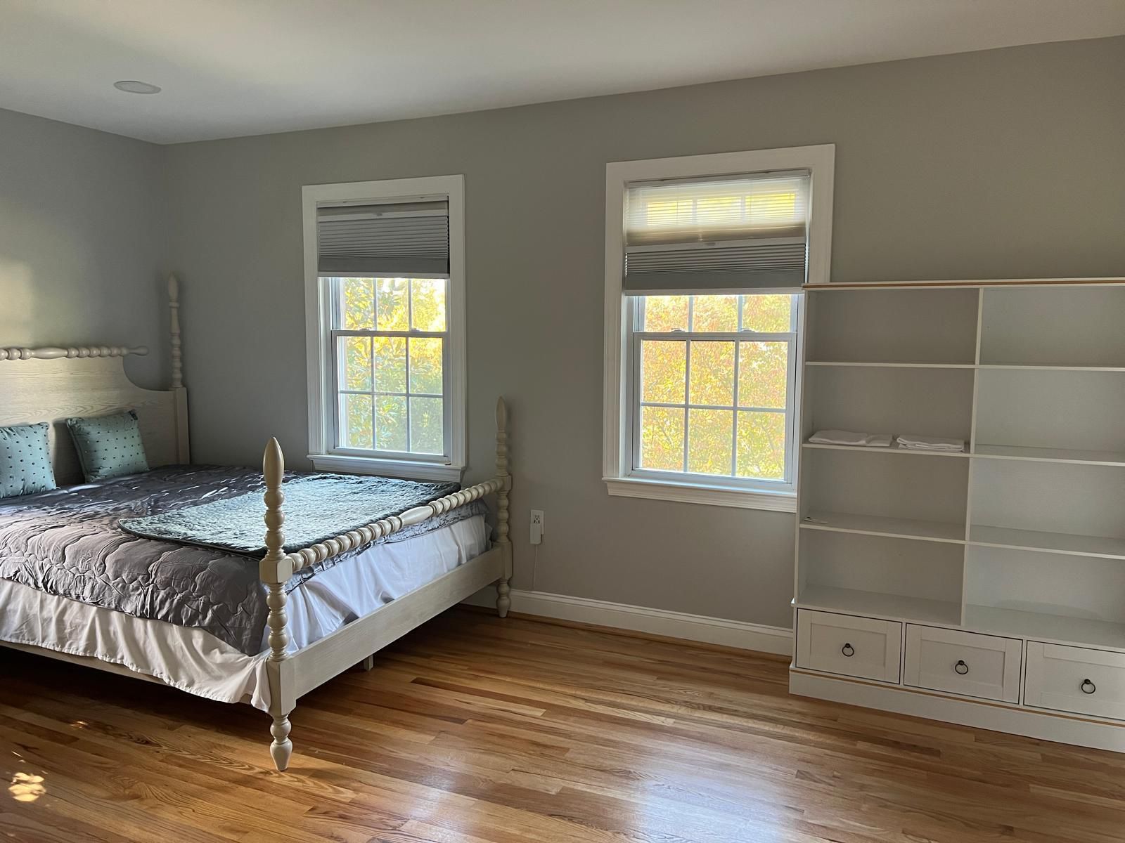 Bright bedroom with light wooden bed frame and natural lighting