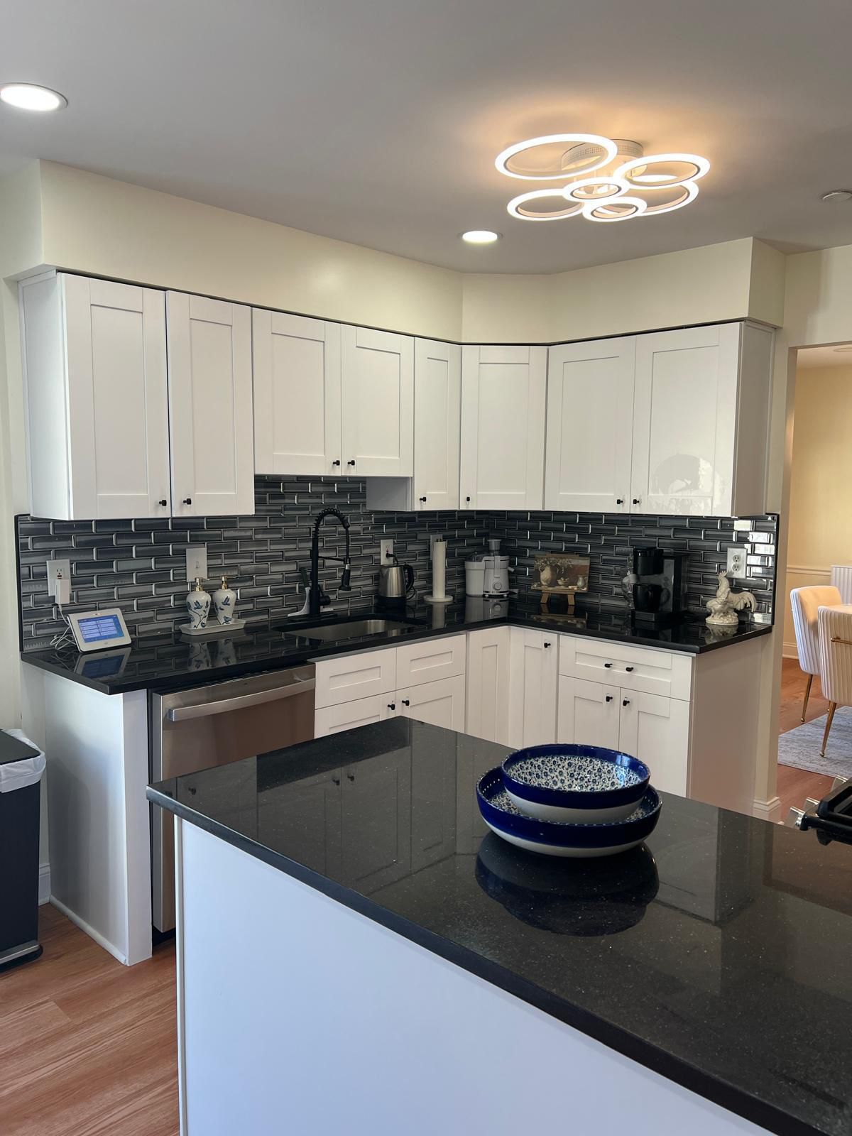 Modern kitchen with white cabinets, black granite countertops, and island